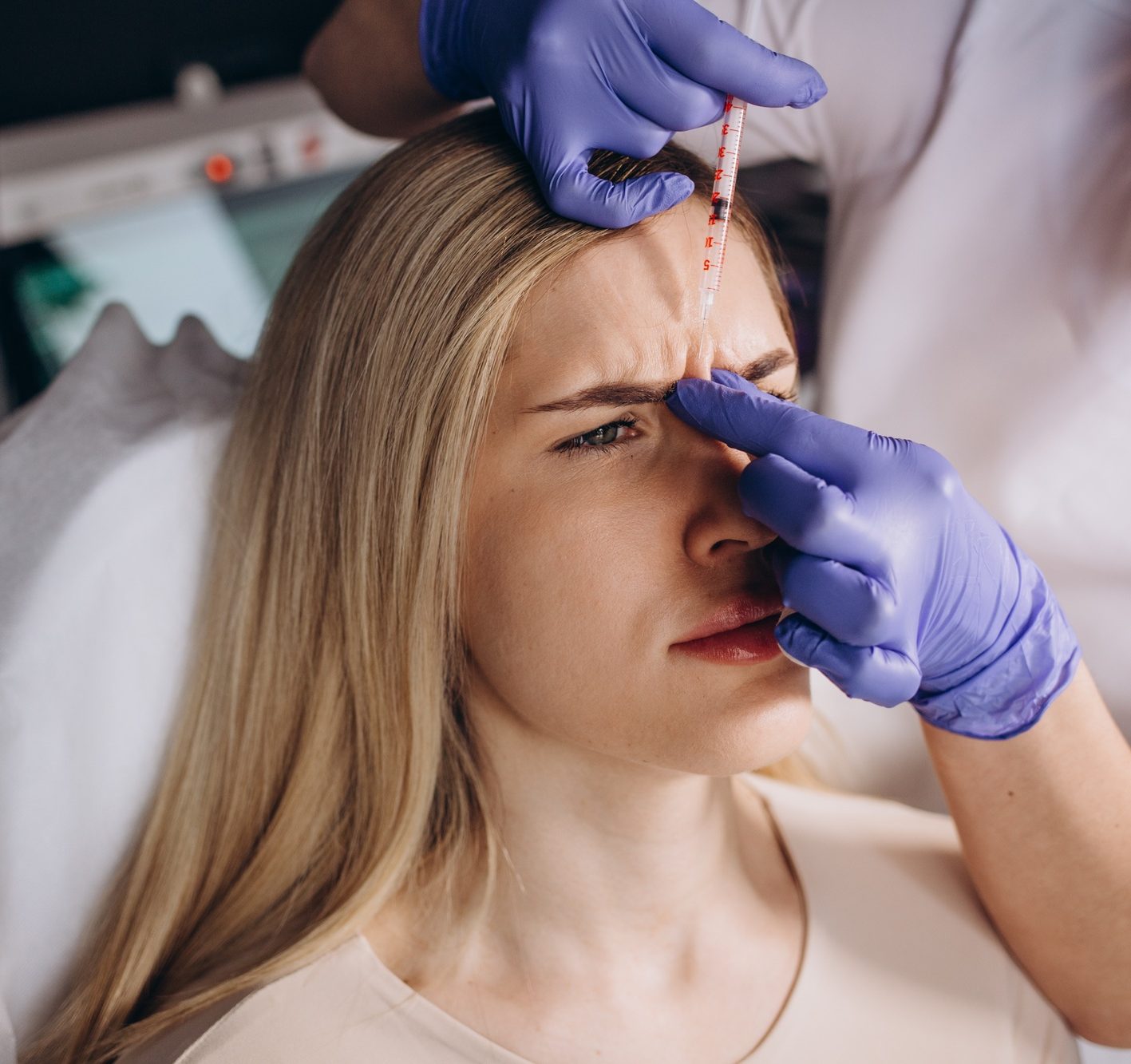 Close up of botox injection in the eyebrow or forehead of female patient